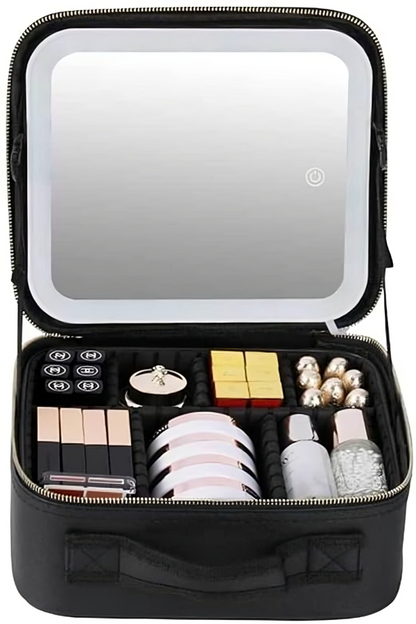 Cosmetiquera negra abierta con espejo LED encendido, compartimentos organizadores y brochas de maquillaje alrededor